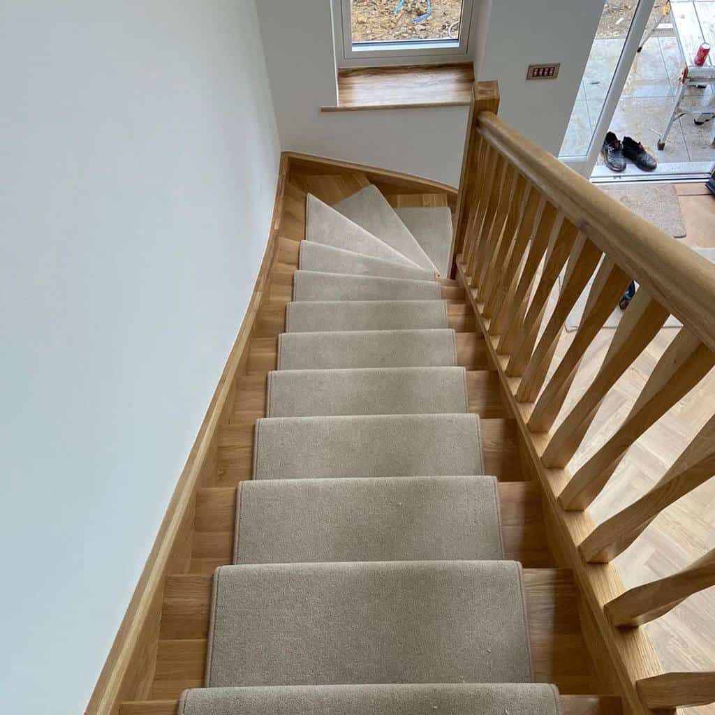wooden staircase with neutral stair runner