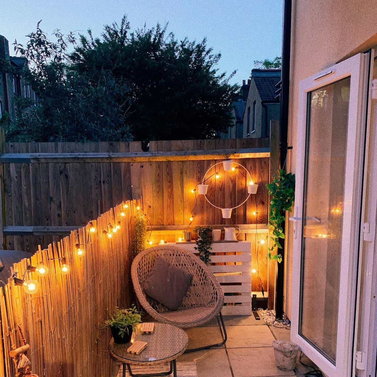 small backyard with bamboo fence and string lights