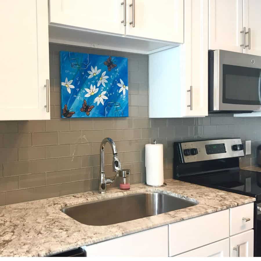 flower and butterfly canvas painting white cabinet kitchen gray backsplash 