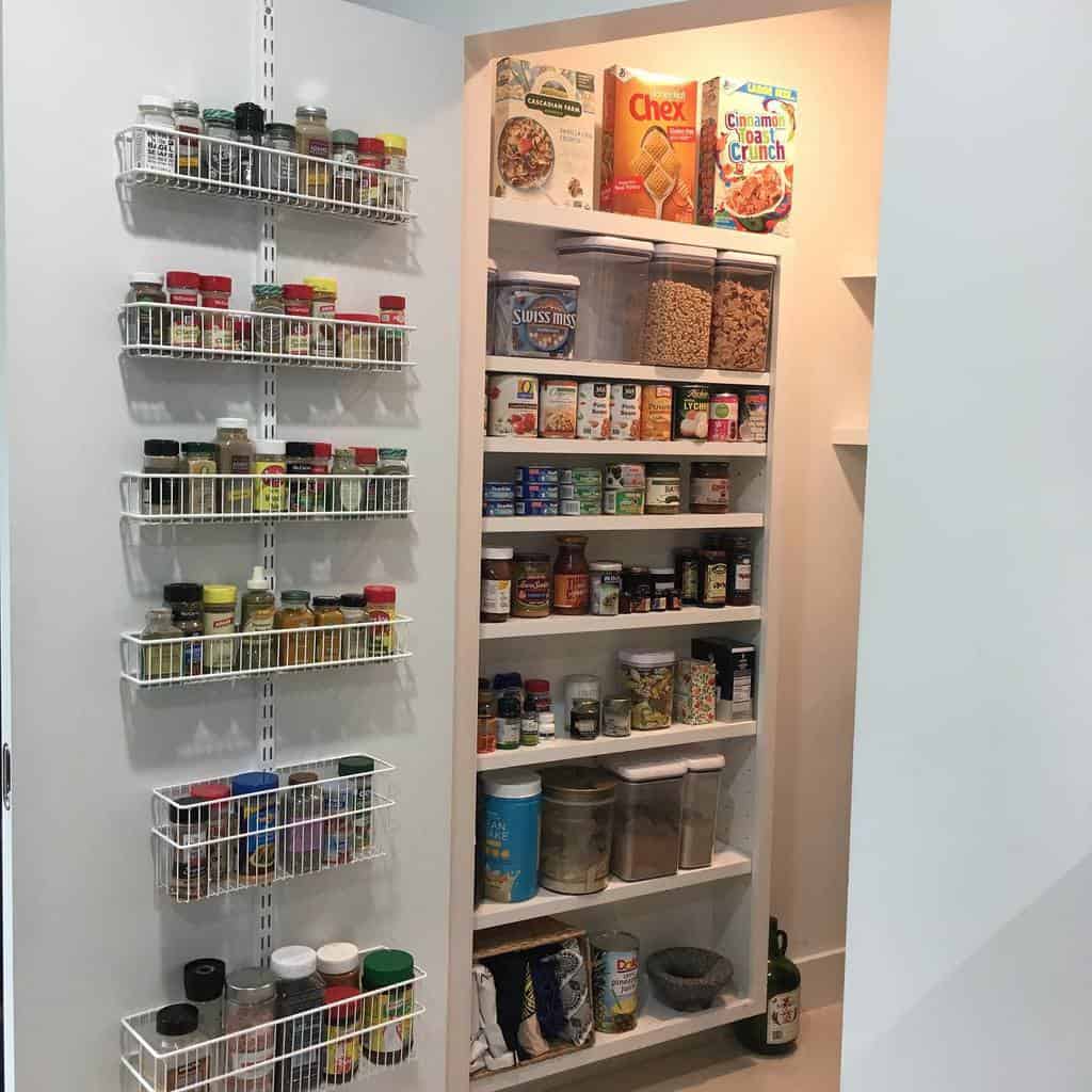 built-in kitchen pantry with shelves and spice racks 