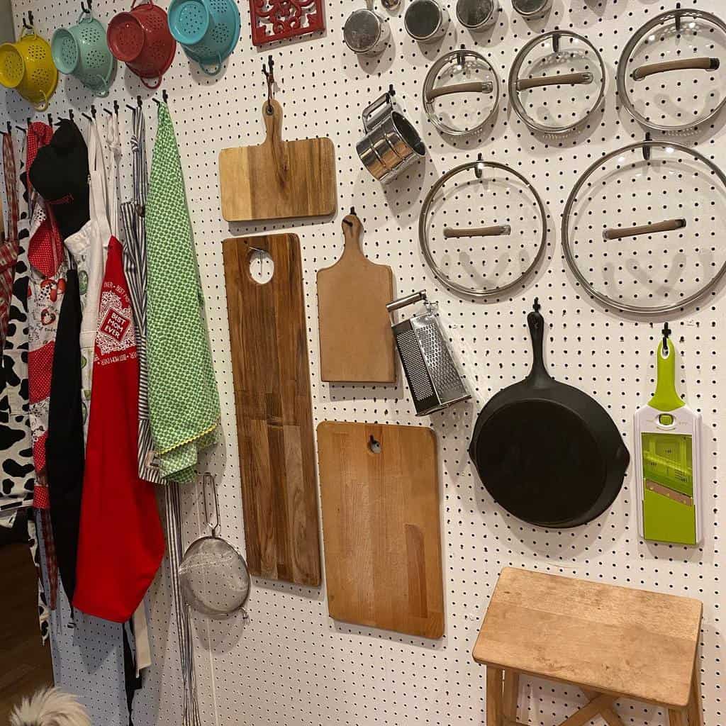 large white kitchen pegboard with cutting boards and pan
