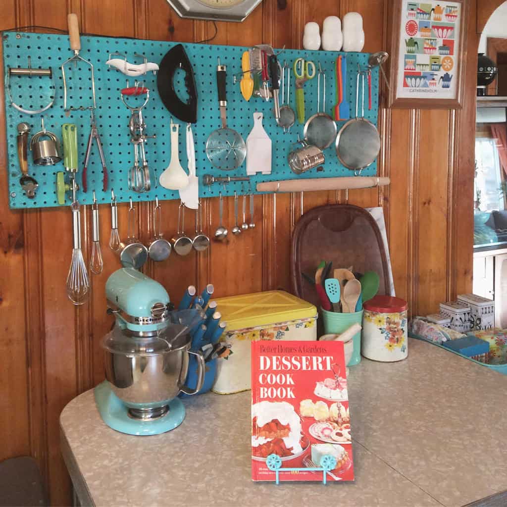 small blue pegboard in kitchen with utensils