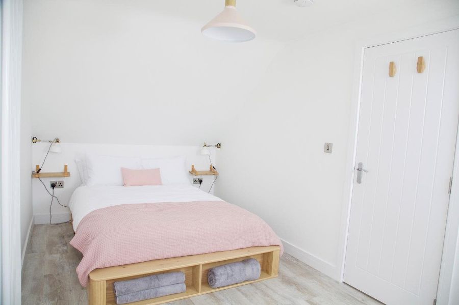 minimalist white bedroom platform bed pink bedspread