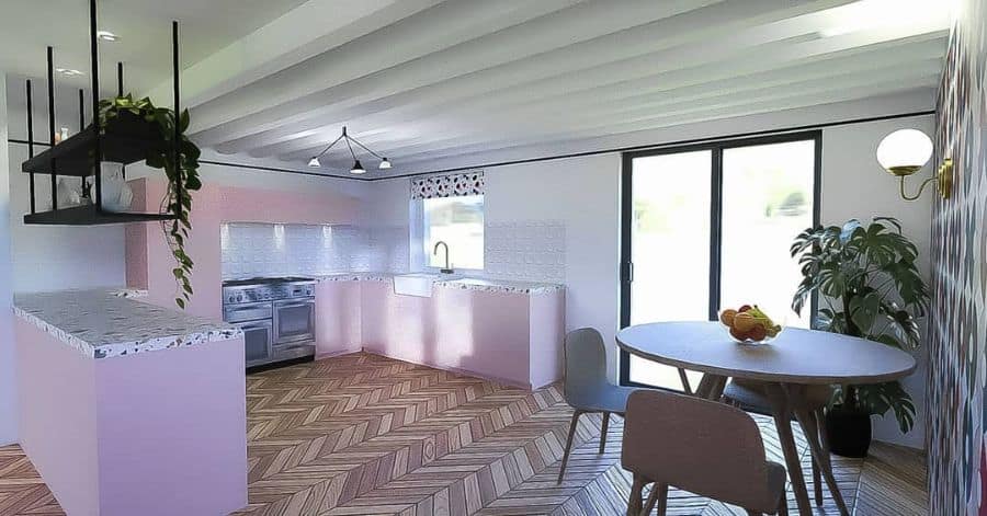 pink kitchen cabinets with subway tile flooring and round dining table and three chairs 