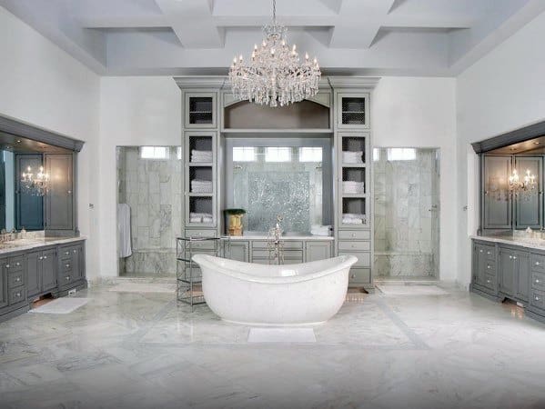 large elegant master bathroom with freestanding white tub and chandelier