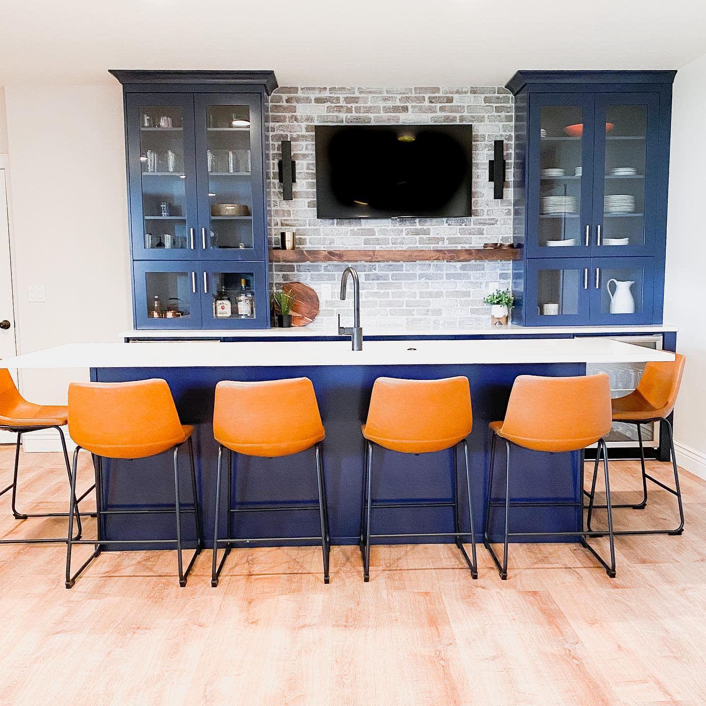 large kitchen with blue cabinets and orange chairs 