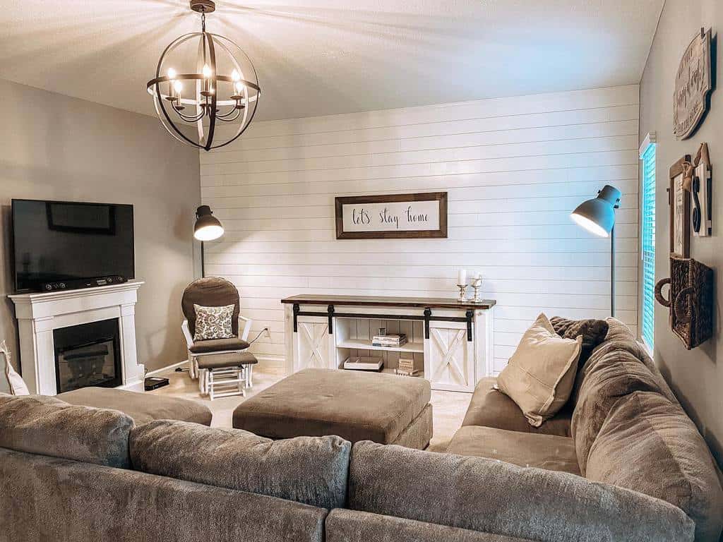 rustic white shiplap wall living room gray sectional sofa fireplace tv on mantle 
