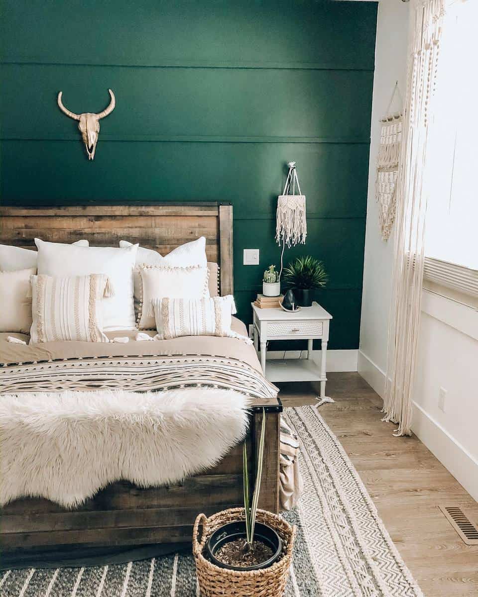 boho bedroom green accent wall wood bed frame white bedside table animal skull