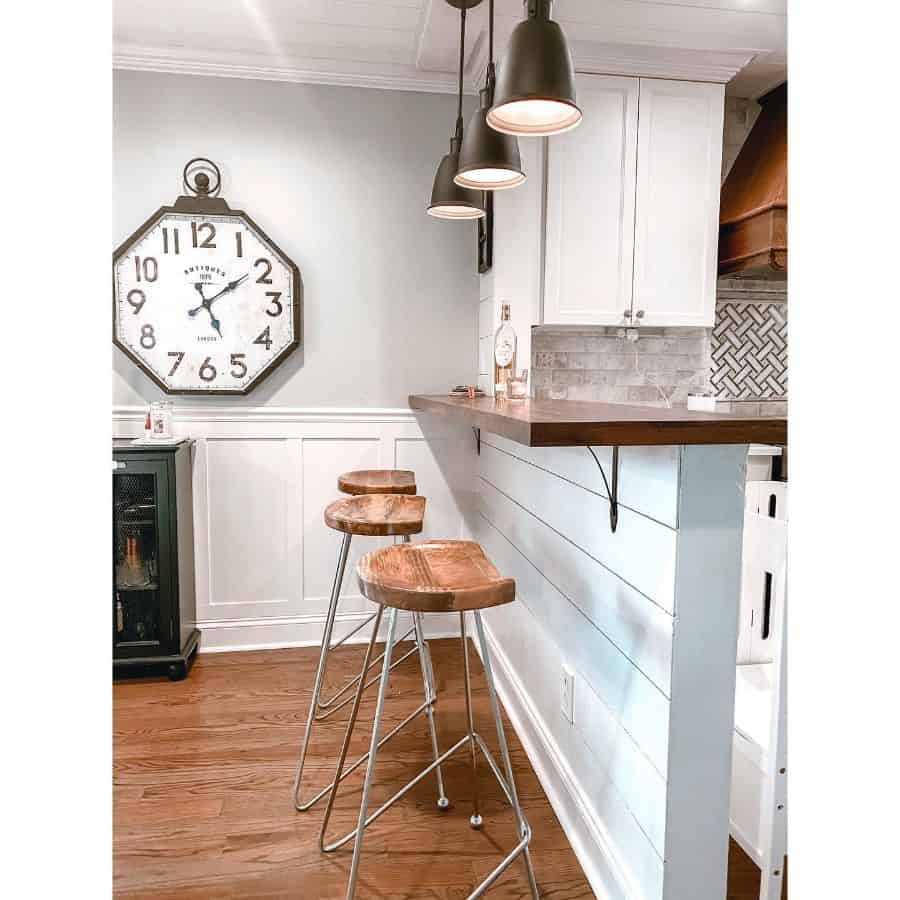 rustic white shiplap kitchen bar wood and metal stools large wall clock 
