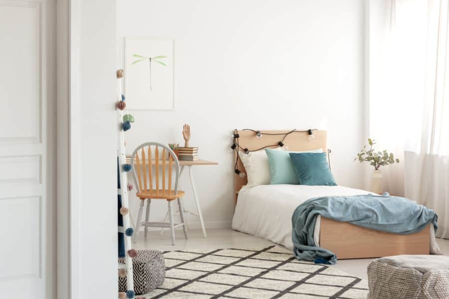 simple single kids bedroom wood bed frame pattern floor rug desk and chair 