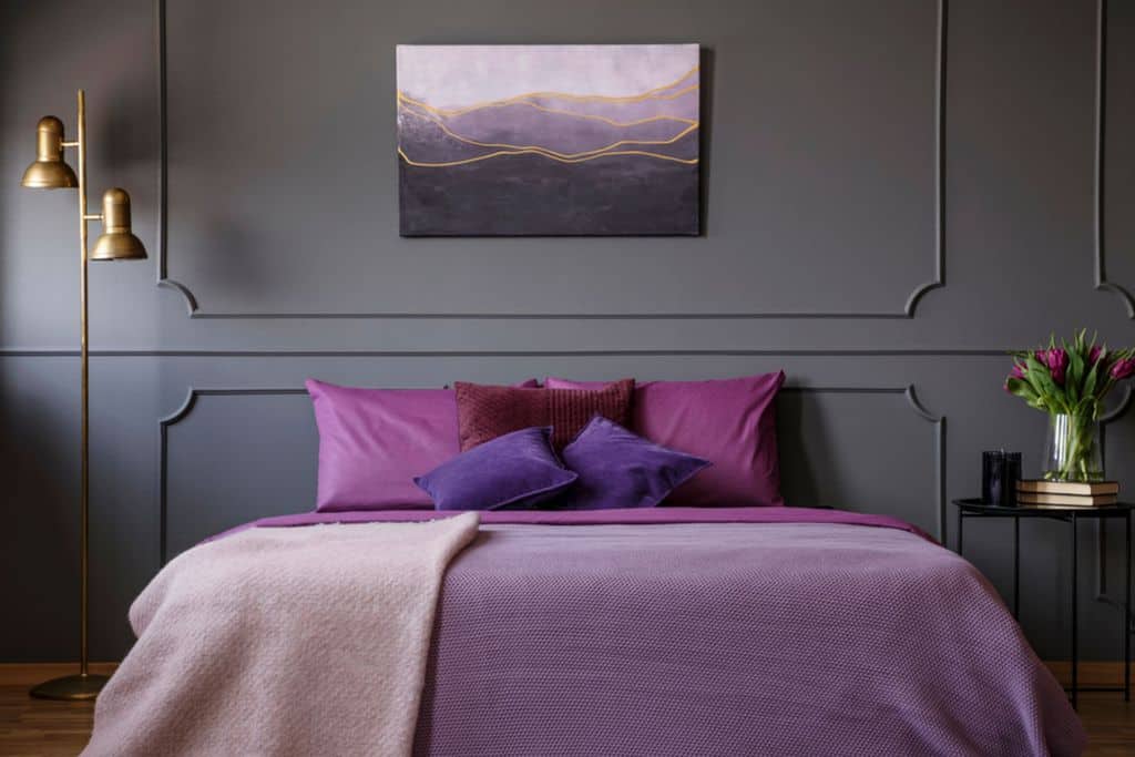 modern bedroom purple bed gray walls gold lamp