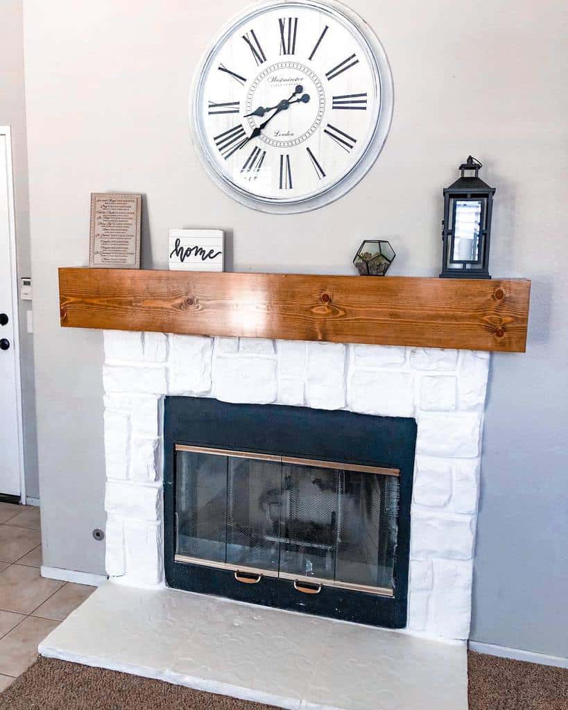 white brick fireplace wood plank mantle with lantern wall clock 