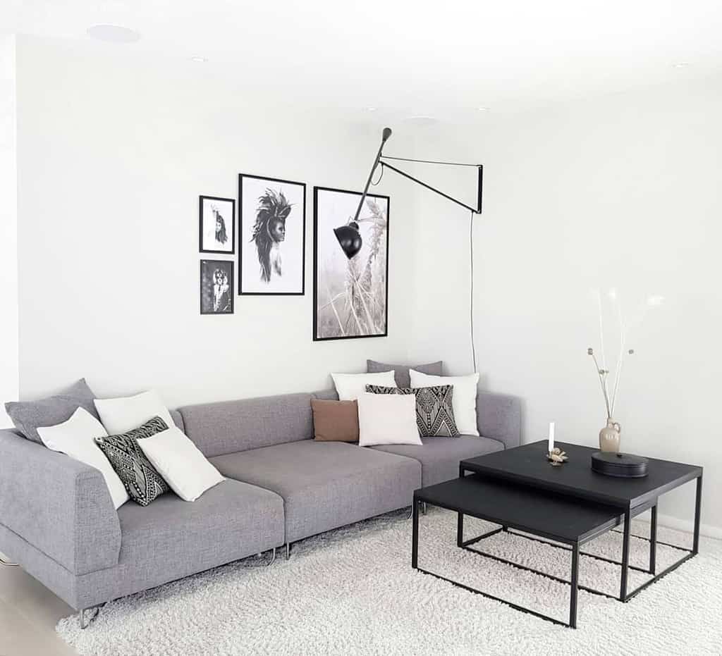 white living room gray sofa black coffee tables framed black and white wall art 