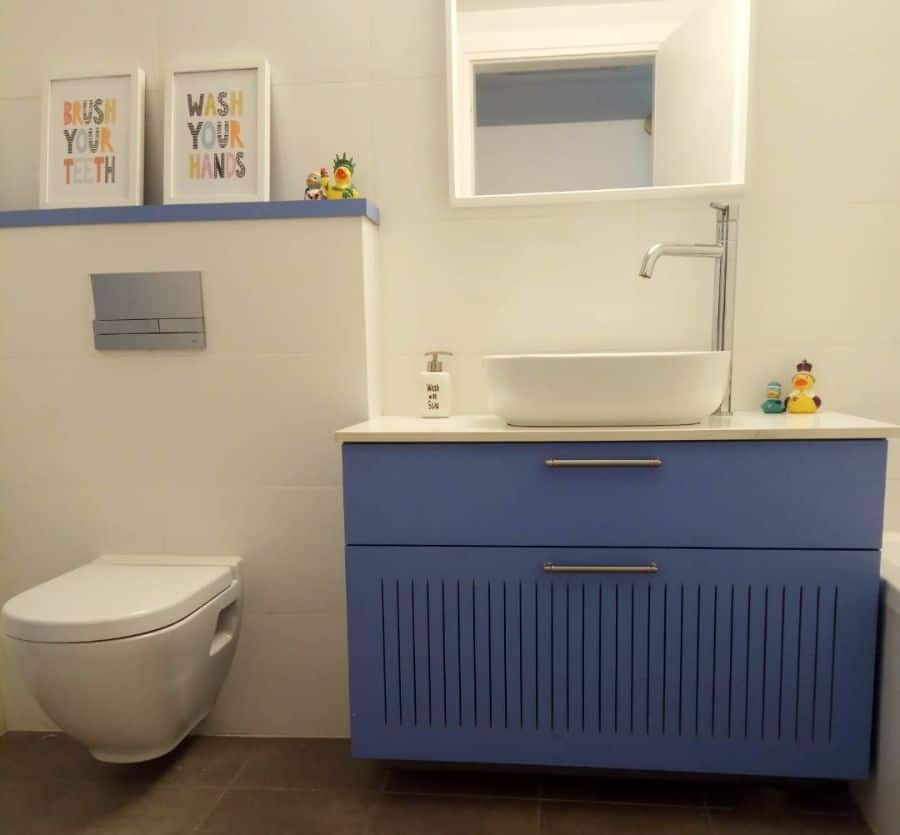 simple kids bathroom blue vanity white wall tiles floating toilet 