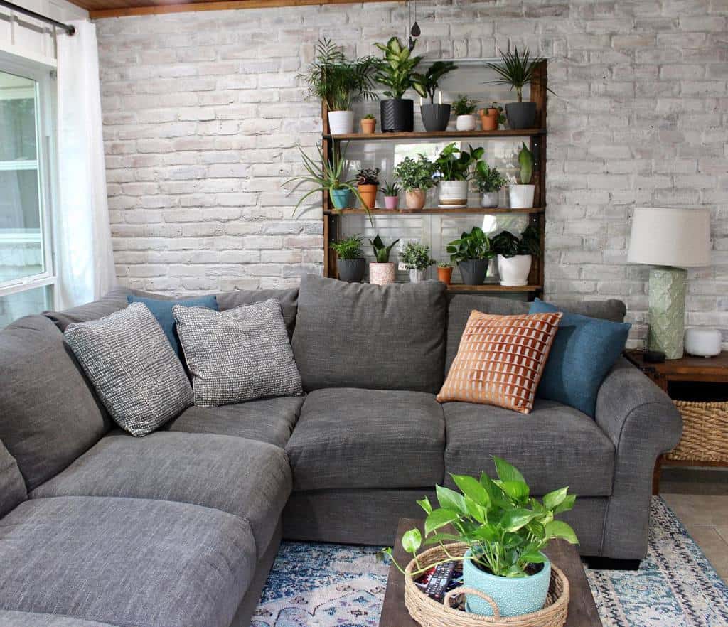 simple sunroom white brick wall brown shelves potted plants