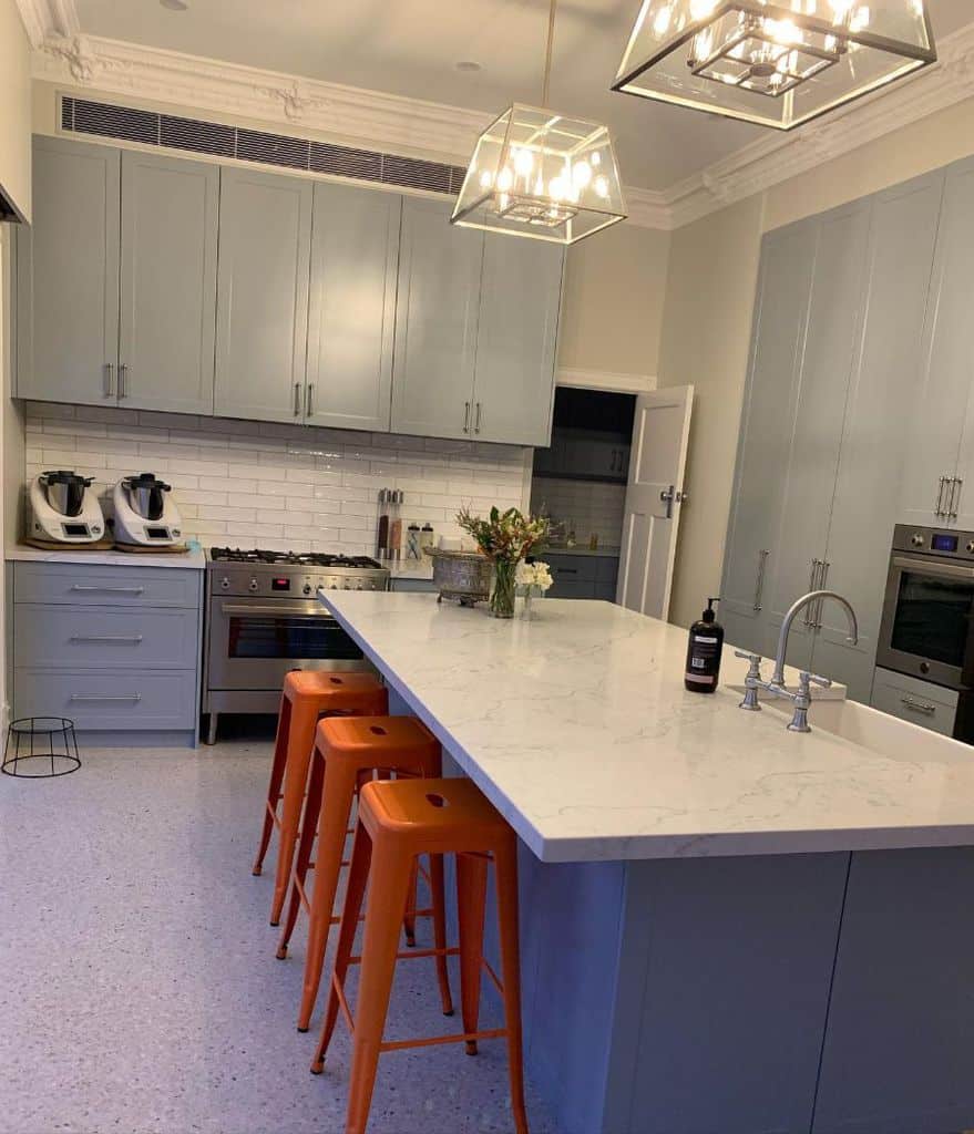 large marble island in gray cabinet kitchen 