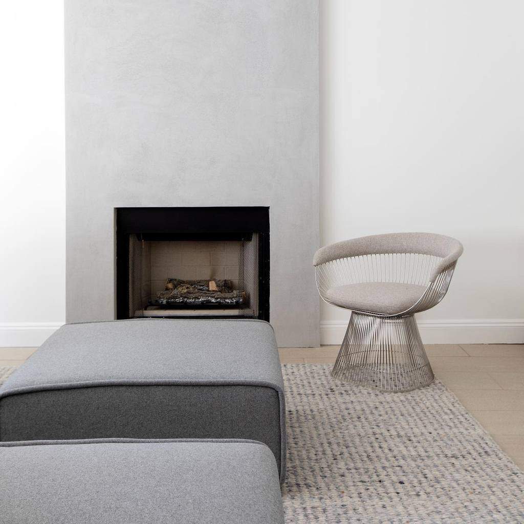 minimalist living room small cement fireplace gray sofa and seat 