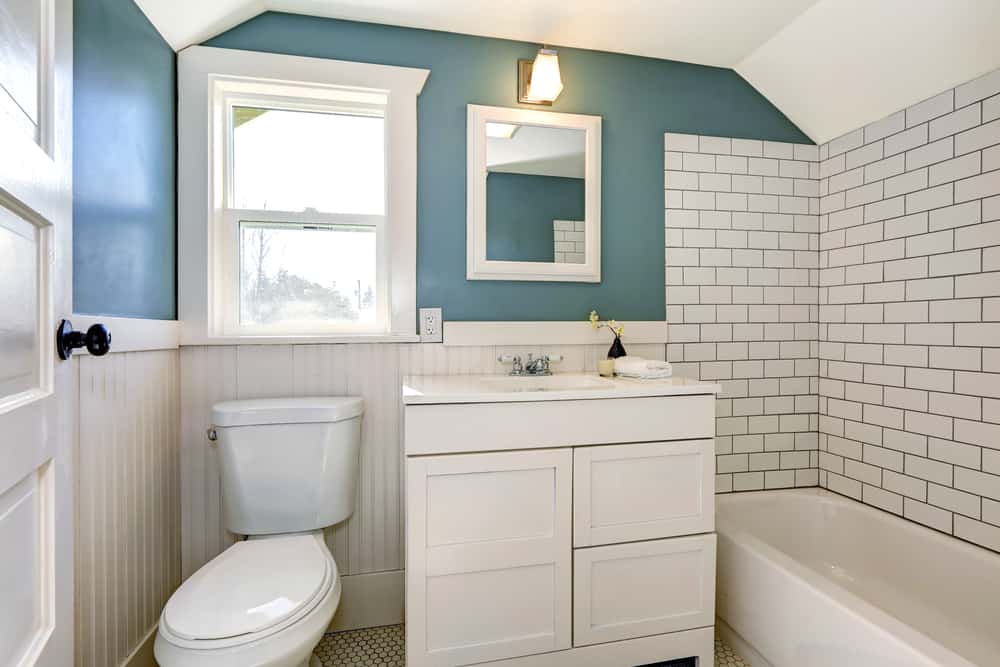 white tile bathroom with green accent walls 