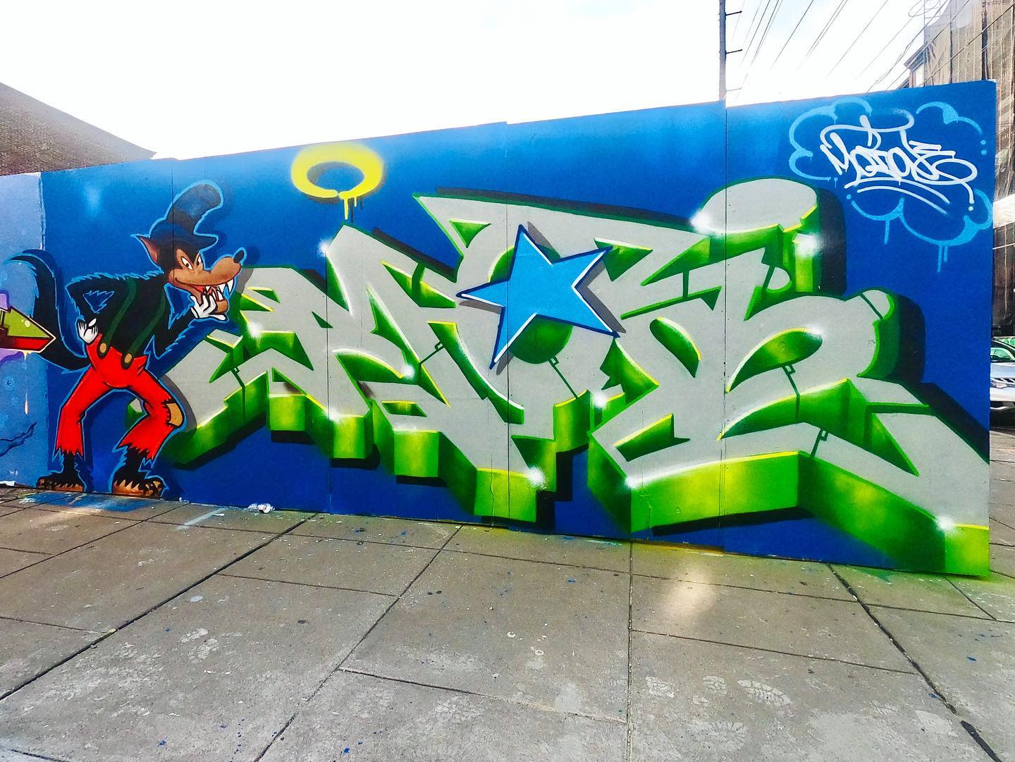 spray painted wall with evil disney character 