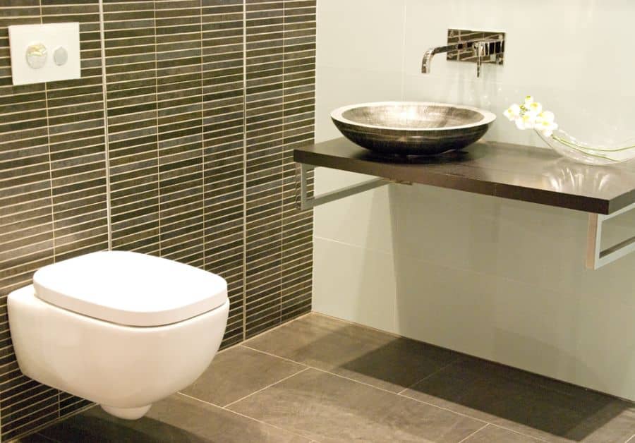 tiled wall in small powder room with floating toilet 