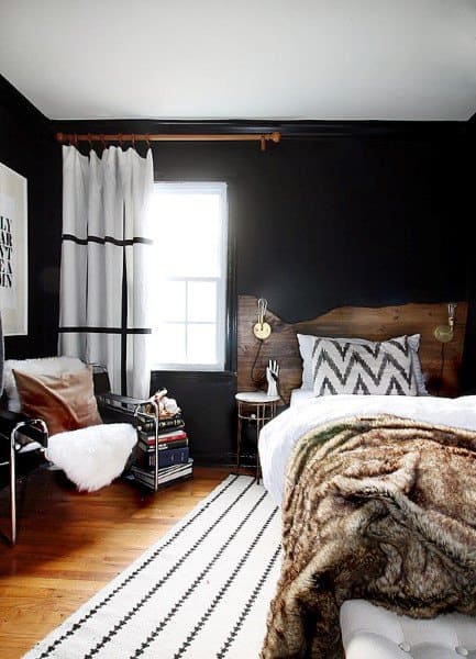 rustic bedroom with black walls and accent chair 
