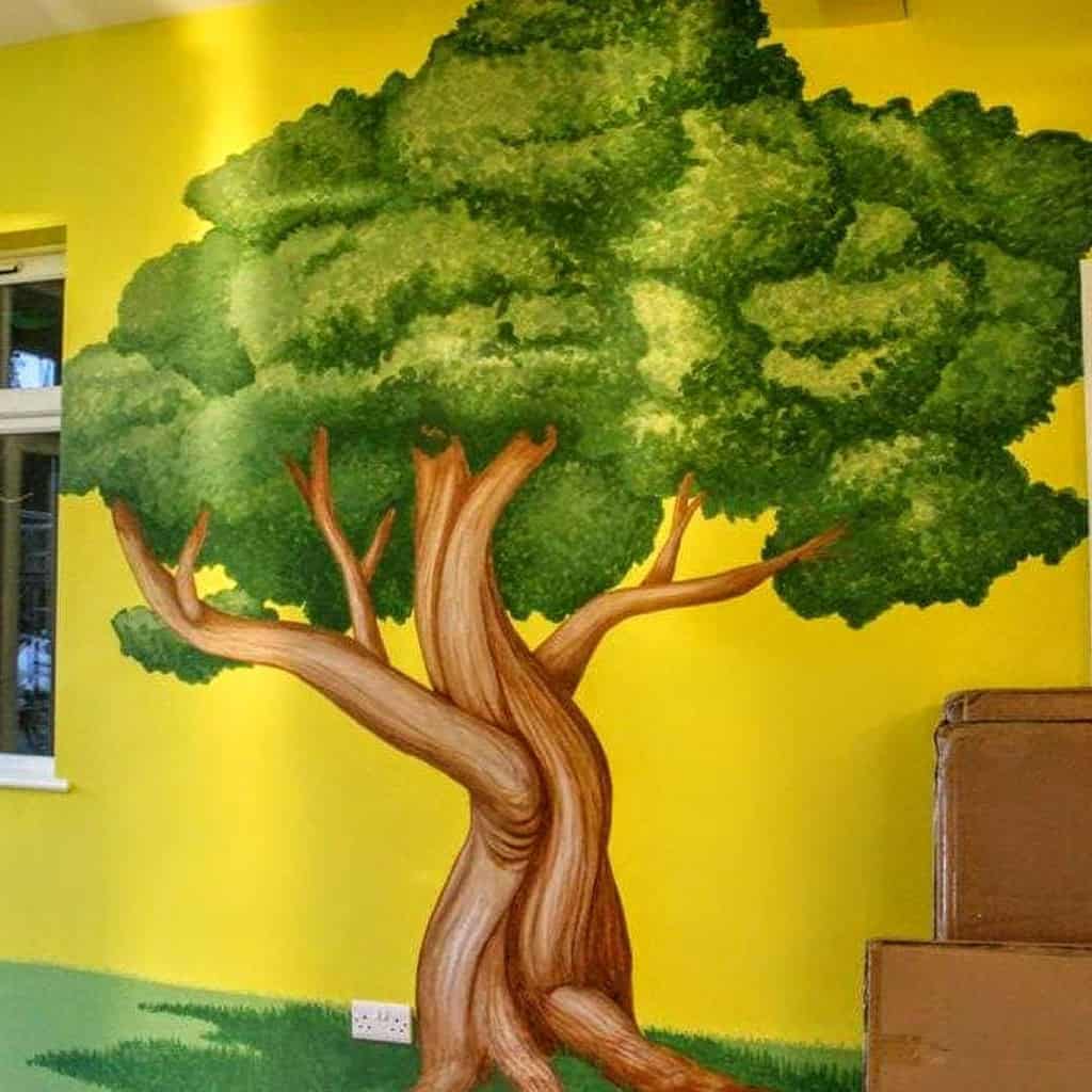 tree mural painted on yellow outside wall 