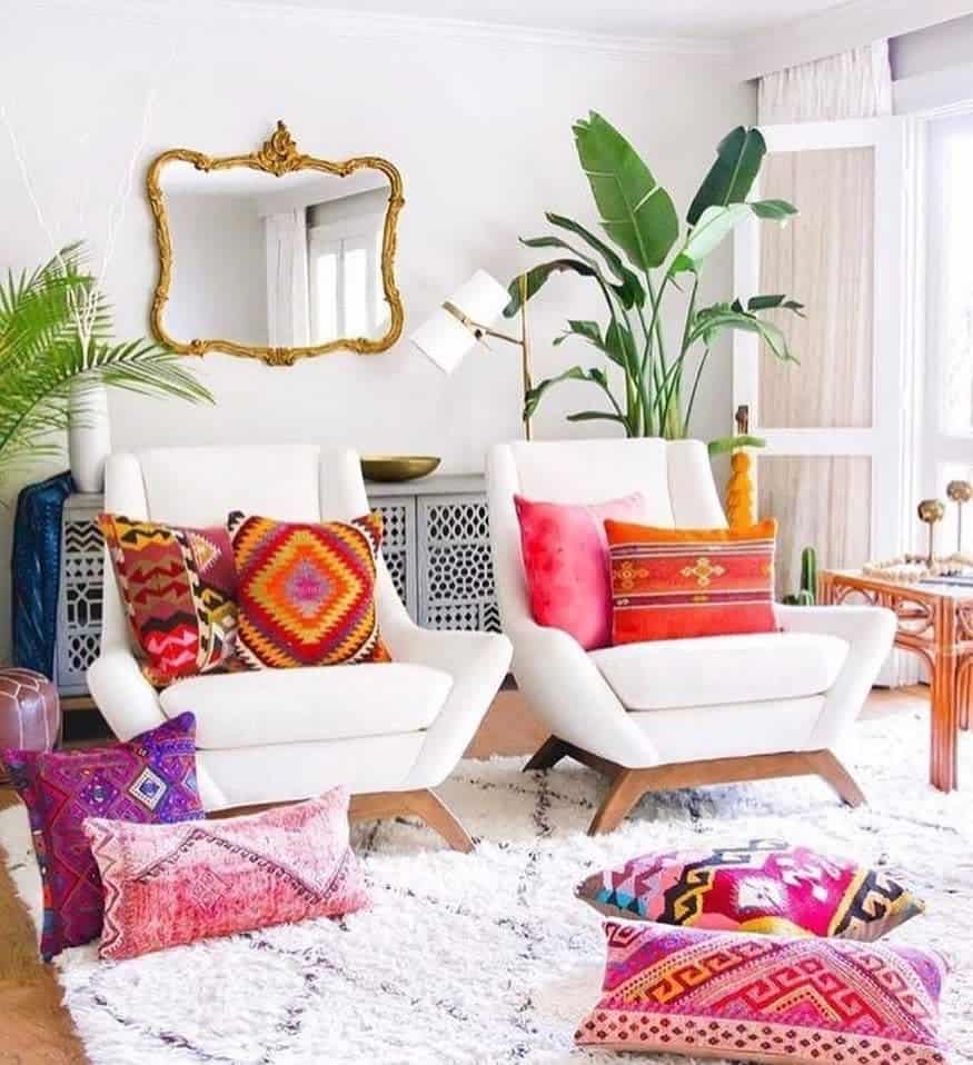 eclectic living room white lounge chairs colorful pillows gold frame mirror 