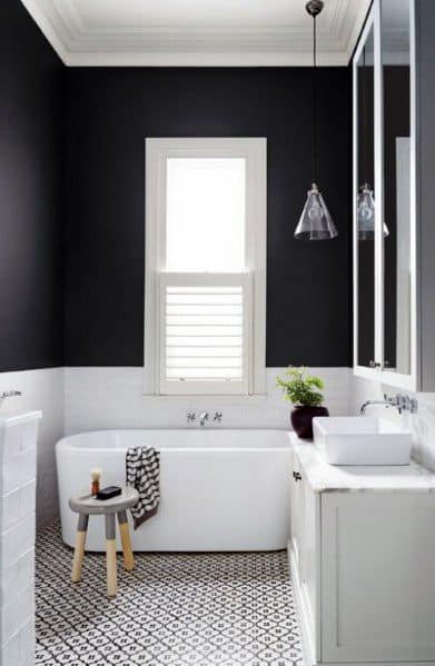 two tone black and white wall master bathroom with white tub and tiled floor 