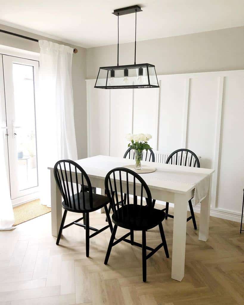 white wall paneling dining room track ceiling lighting black chairs white table 