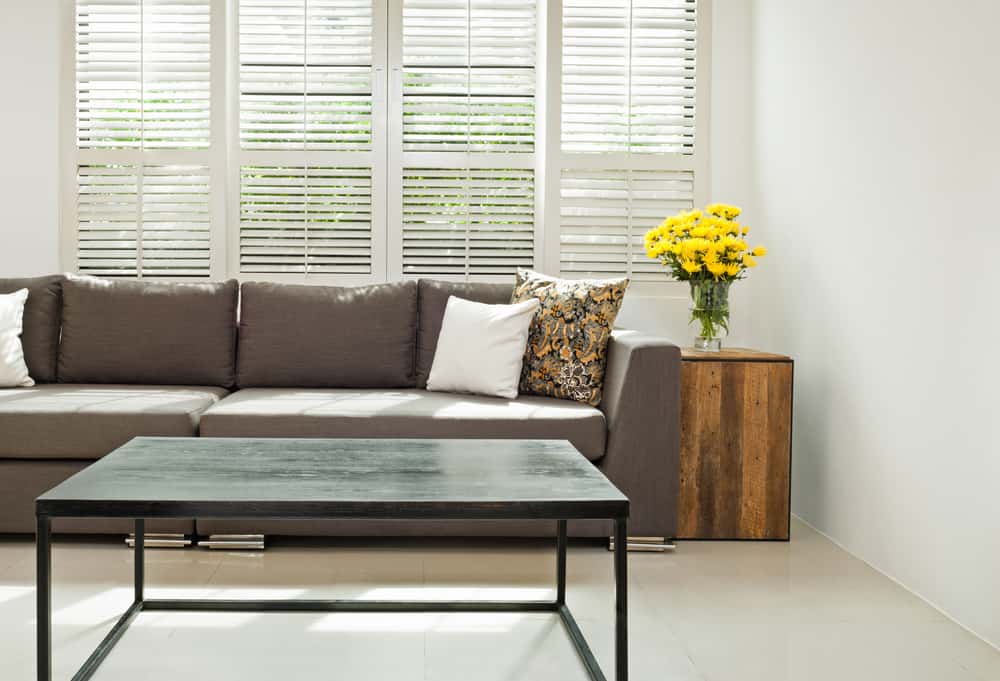 white window shutters gray couch black coffee table 