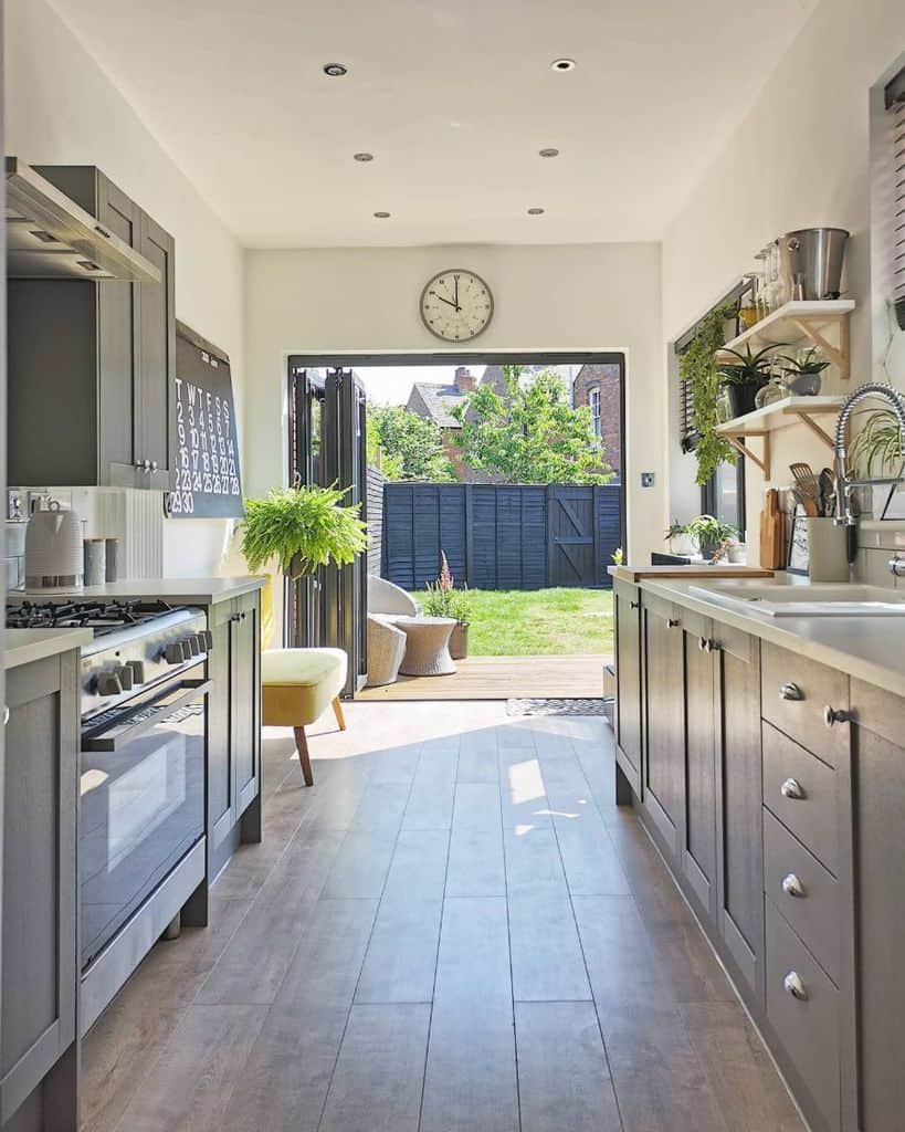 gray cabinet galley kitchen open to backyard 